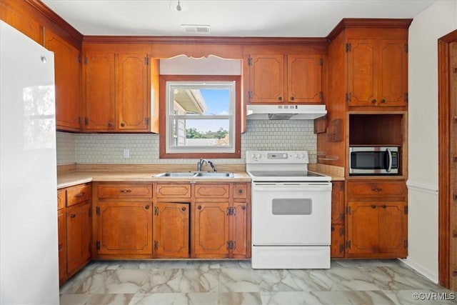 kitchen with a sink, marble finish floor, under cabinet range hood, and white appliances
