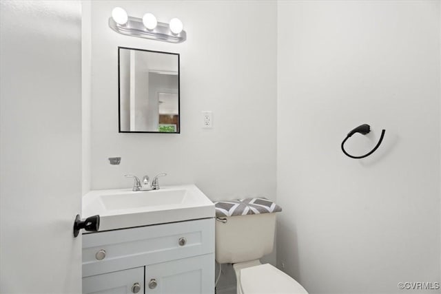 half bathroom with vanity and toilet