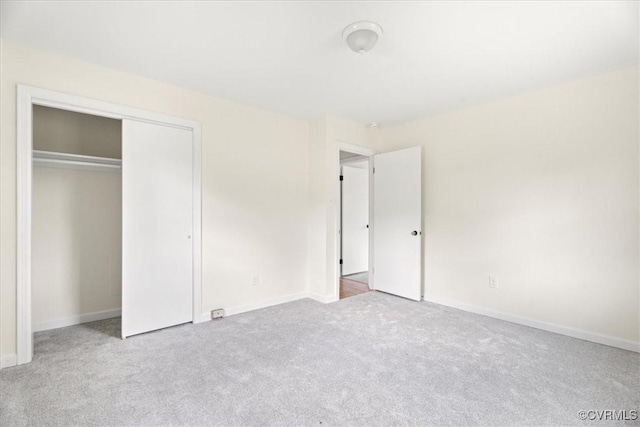unfurnished bedroom featuring carpet floors, baseboards, and a closet