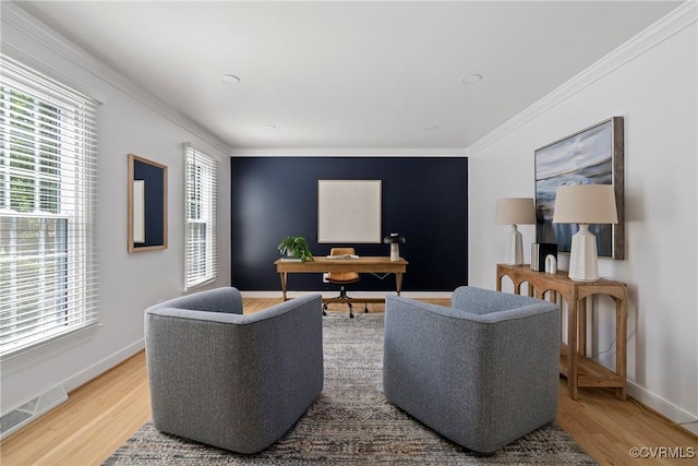 living area featuring crown molding, visible vents, a healthy amount of sunlight, and wood finished floors