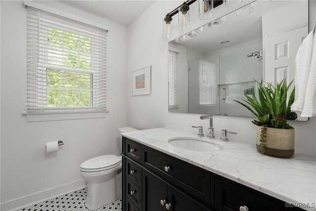 full bathroom with vanity, toilet, baseboards, and a stall shower
