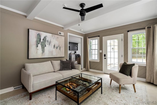 living area featuring baseboards, visible vents, plenty of natural light, and beam ceiling
