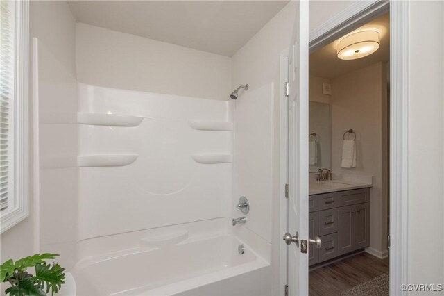 bathroom with vanity, wood finished floors, and shower / washtub combination