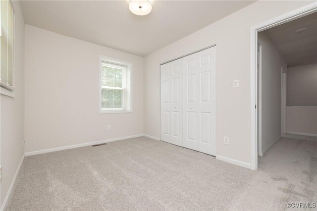 unfurnished bedroom featuring a closet, baseboards, and carpet flooring