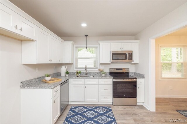 kitchen featuring a sink, white cabinets, stainless steel appliances, and recessed lighting
