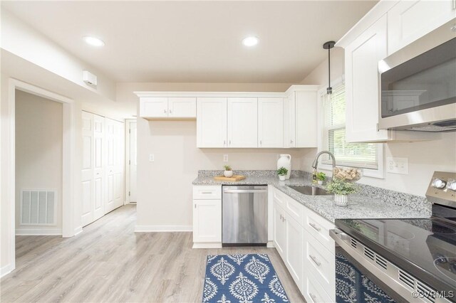 kitchen with visible vents, a sink, white cabinetry, and stainless steel appliances