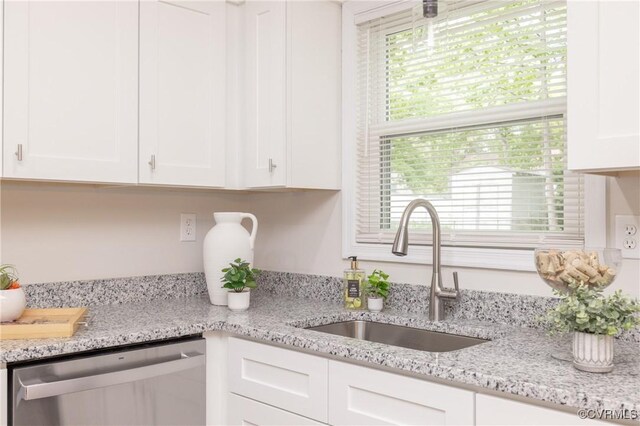 kitchen featuring a sink, light stone countertops, white cabinetry, and dishwasher