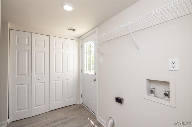 washroom with laundry area, visible vents, hookup for a washing machine, and light wood-style floors