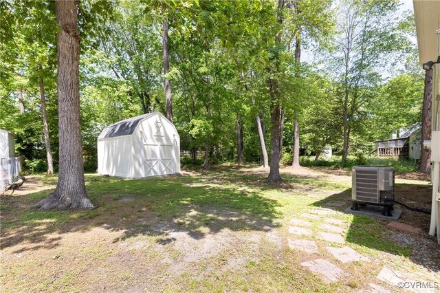view of yard with an outdoor structure, central air condition unit, and a shed