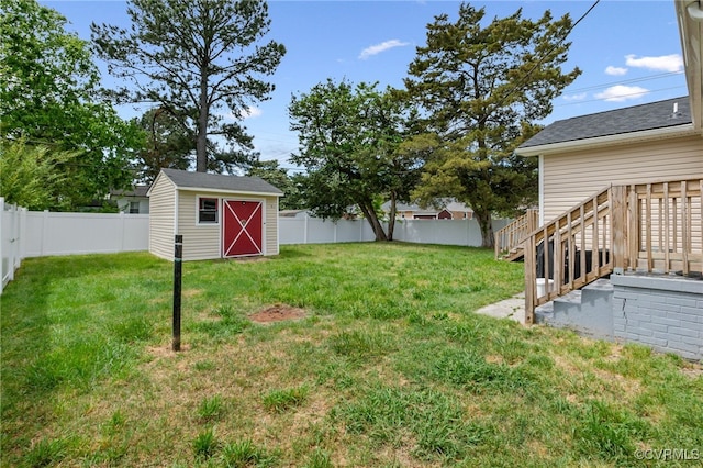 view of yard featuring a storage shed, an outbuilding, and a fenced backyard