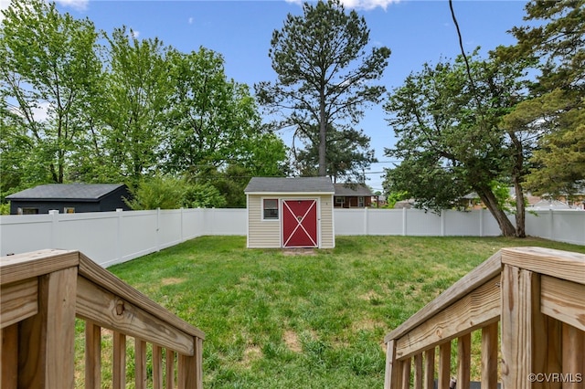 view of yard with a fenced backyard, an outbuilding, and a storage shed