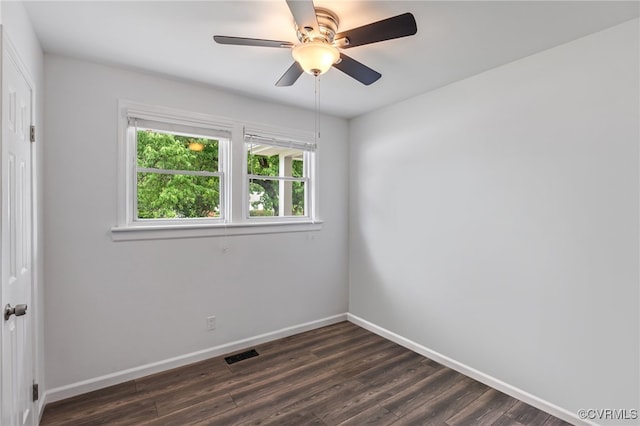 empty room featuring visible vents, baseboards, ceiling fan, and dark wood-style floors