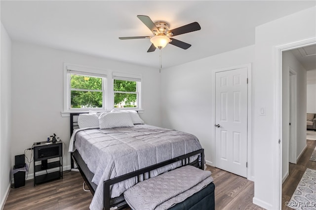 bedroom with baseboards, attic access, and wood finished floors