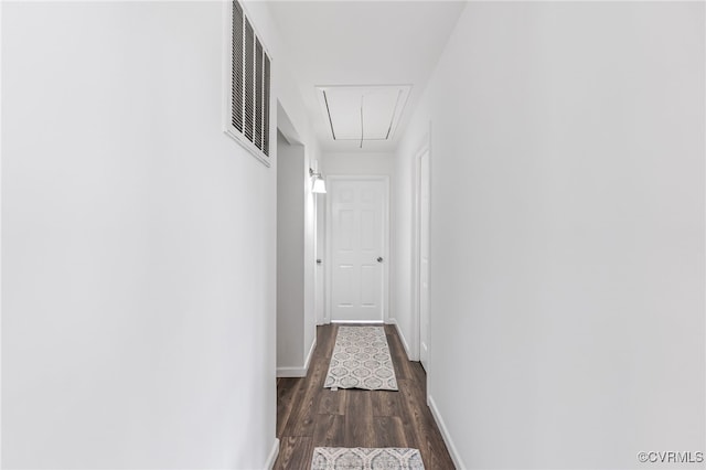 corridor with visible vents, attic access, dark wood finished floors, and baseboards