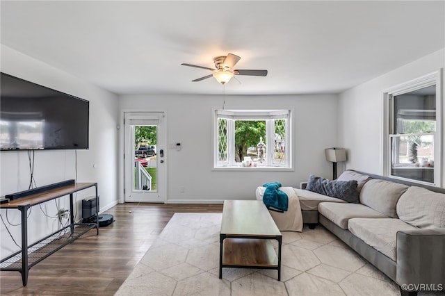 living room with baseboards, ceiling fan, and wood finished floors