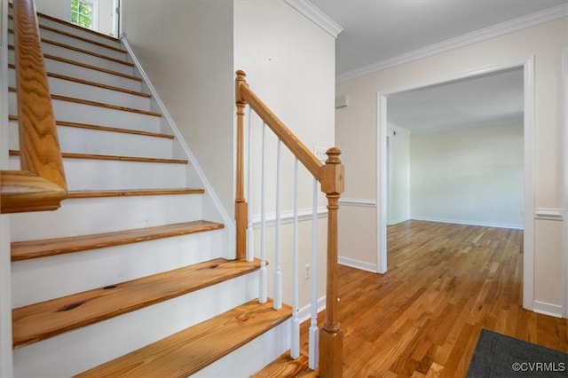 stairs featuring crown molding, baseboards, and wood finished floors