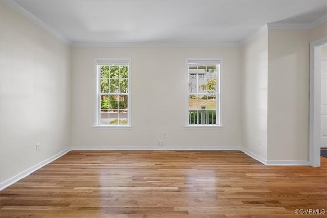 empty room featuring plenty of natural light, light wood-style floors, and crown molding