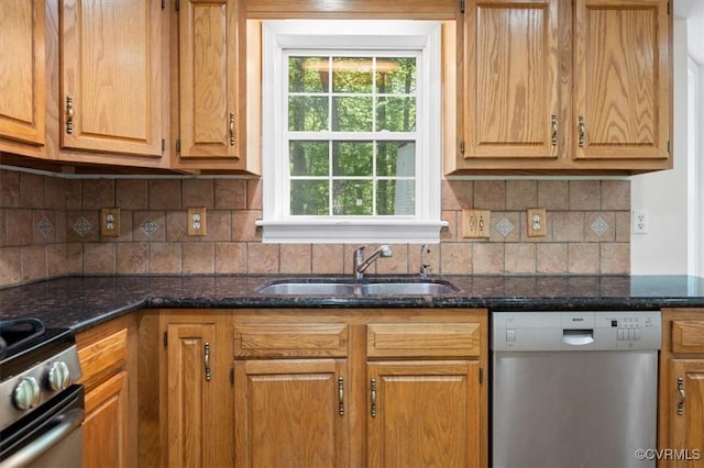 kitchen with decorative backsplash, dishwasher, a sink, dark stone countertops, and range