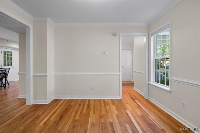 empty room with baseboards, ornamental molding, and light wood-style flooring