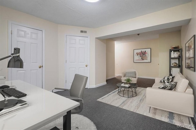 office area featuring baseboards, carpet, a textured ceiling, and visible vents