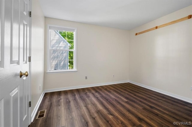 unfurnished room with baseboards, wood finished floors, and visible vents