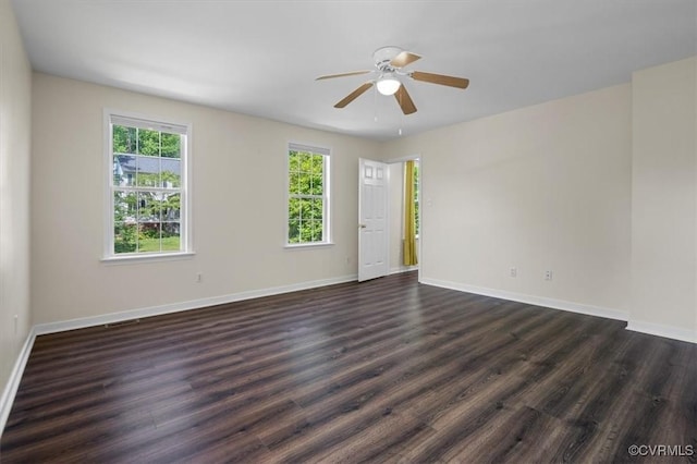spare room with baseboards, ceiling fan, and dark wood-style floors