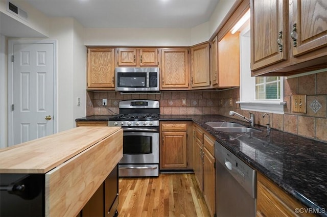kitchen featuring visible vents, butcher block countertops, light wood-style floors, a sink, and appliances with stainless steel finishes