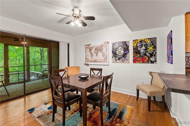dining space featuring baseboards, a ceiling fan, and wood finished floors