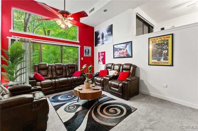 carpeted living room with ceiling fan, visible vents, plenty of natural light, and baseboards