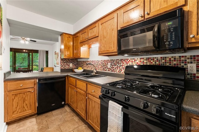 kitchen featuring a sink, decorative backsplash, black appliances, and dark countertops