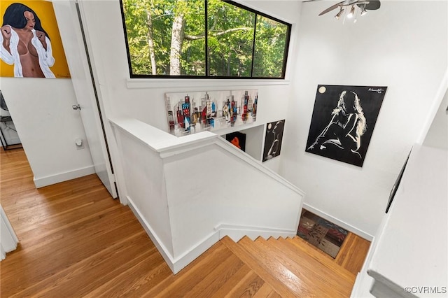 staircase with a ceiling fan, baseboards, and wood finished floors