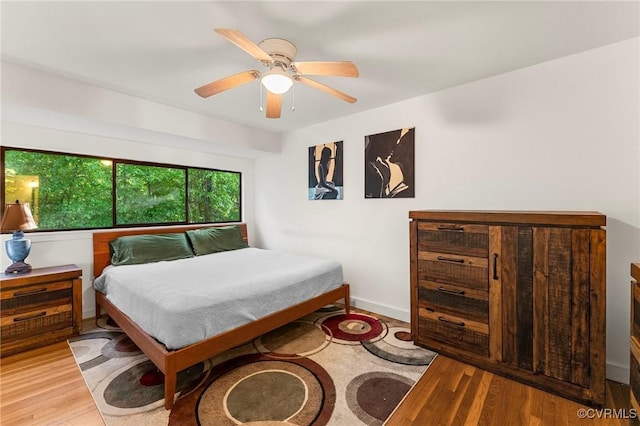 bedroom featuring baseboards, ceiling fan, and wood finished floors