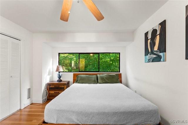 bedroom with a closet, a ceiling fan, and wood finished floors