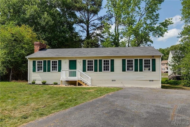 view of front of property featuring a chimney, driveway, a front yard, and crawl space