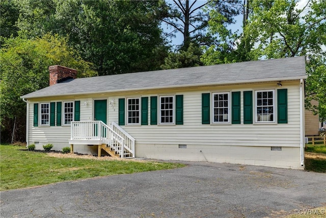 view of front of home with roof with shingles, a chimney, and crawl space