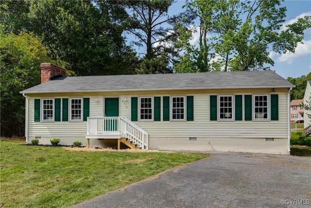 view of front of property featuring roof with shingles, a chimney, a front lawn, and crawl space