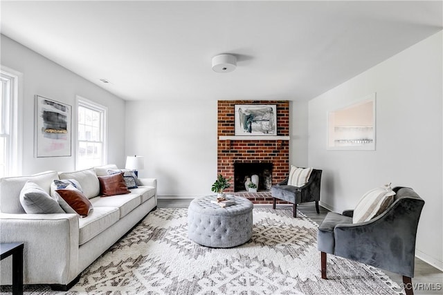 living area featuring baseboards, wood finished floors, and a fireplace