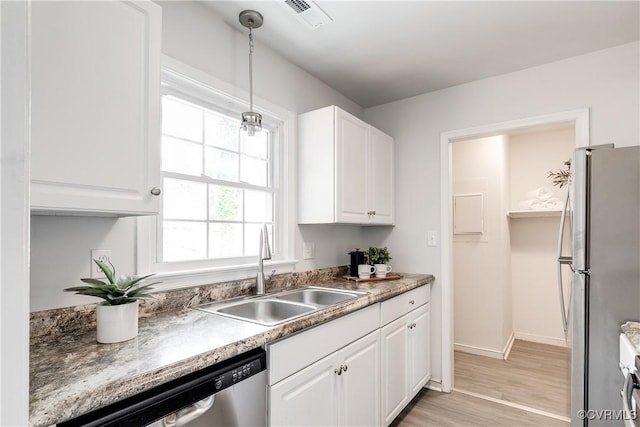 kitchen with visible vents, white cabinets, a sink, light wood-style flooring, and stainless steel appliances