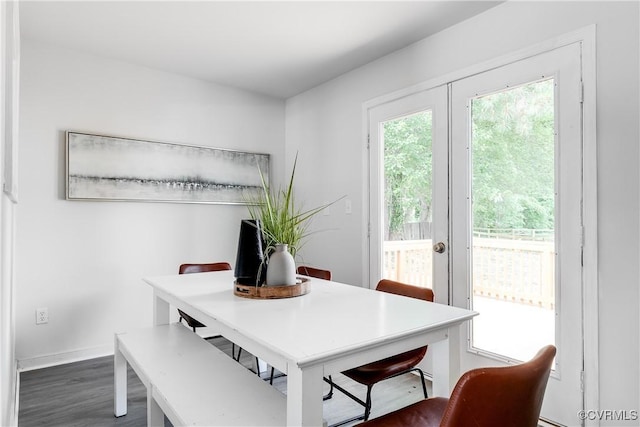 dining space with baseboards and wood finished floors