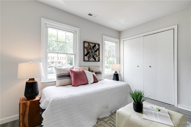 bedroom featuring baseboards, multiple windows, and visible vents