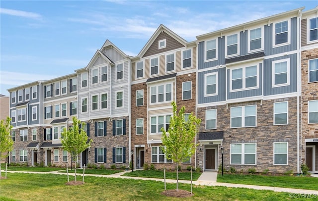 townhome / multi-family property featuring a front lawn