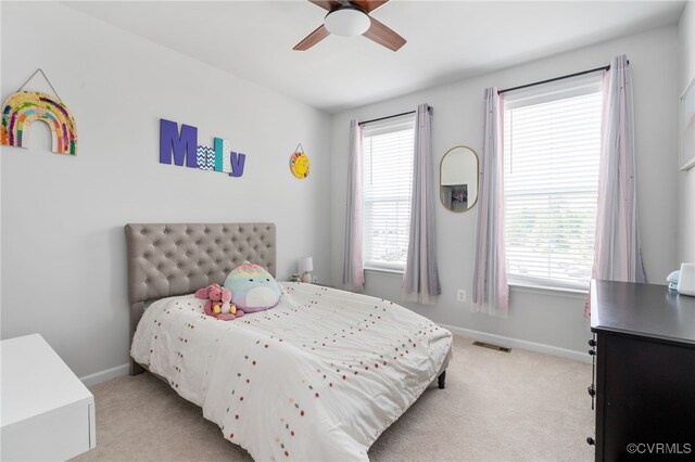 bedroom featuring visible vents, light carpet, and multiple windows