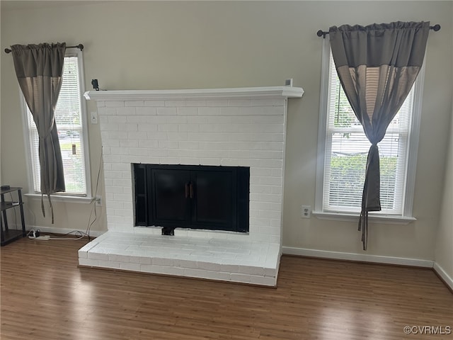 details with a brick fireplace, baseboards, and wood finished floors