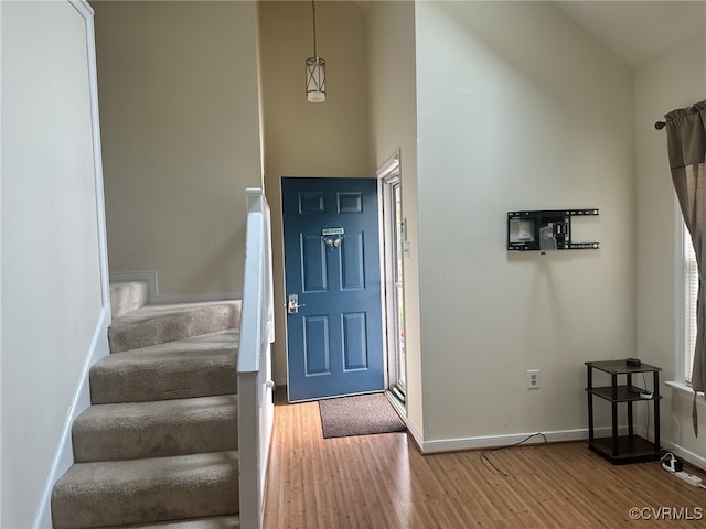 foyer with stairway, wood finished floors, and baseboards