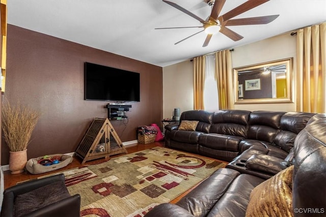 living room featuring baseboards, a ceiling fan, and wood finished floors