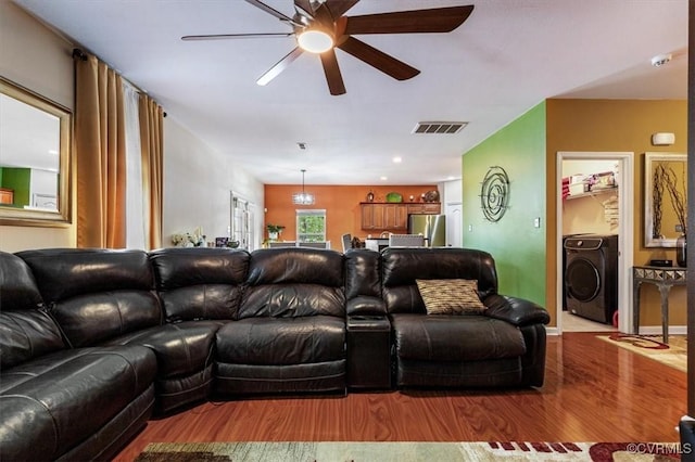 living area featuring visible vents, a ceiling fan, washer / clothes dryer, and wood finished floors