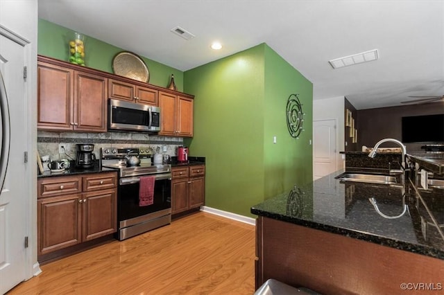 kitchen with visible vents, a sink, appliances with stainless steel finishes, and light wood-type flooring