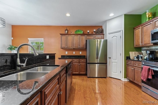 kitchen with recessed lighting, a sink, light wood finished floors, and appliances with stainless steel finishes