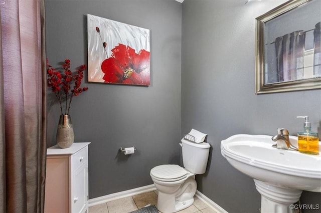 bathroom featuring tile patterned flooring, a sink, baseboards, and toilet
