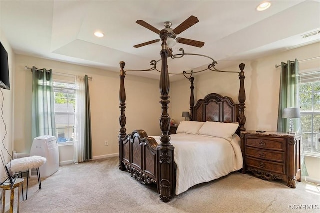 bedroom featuring light carpet, baseboards, ceiling fan, recessed lighting, and a tray ceiling